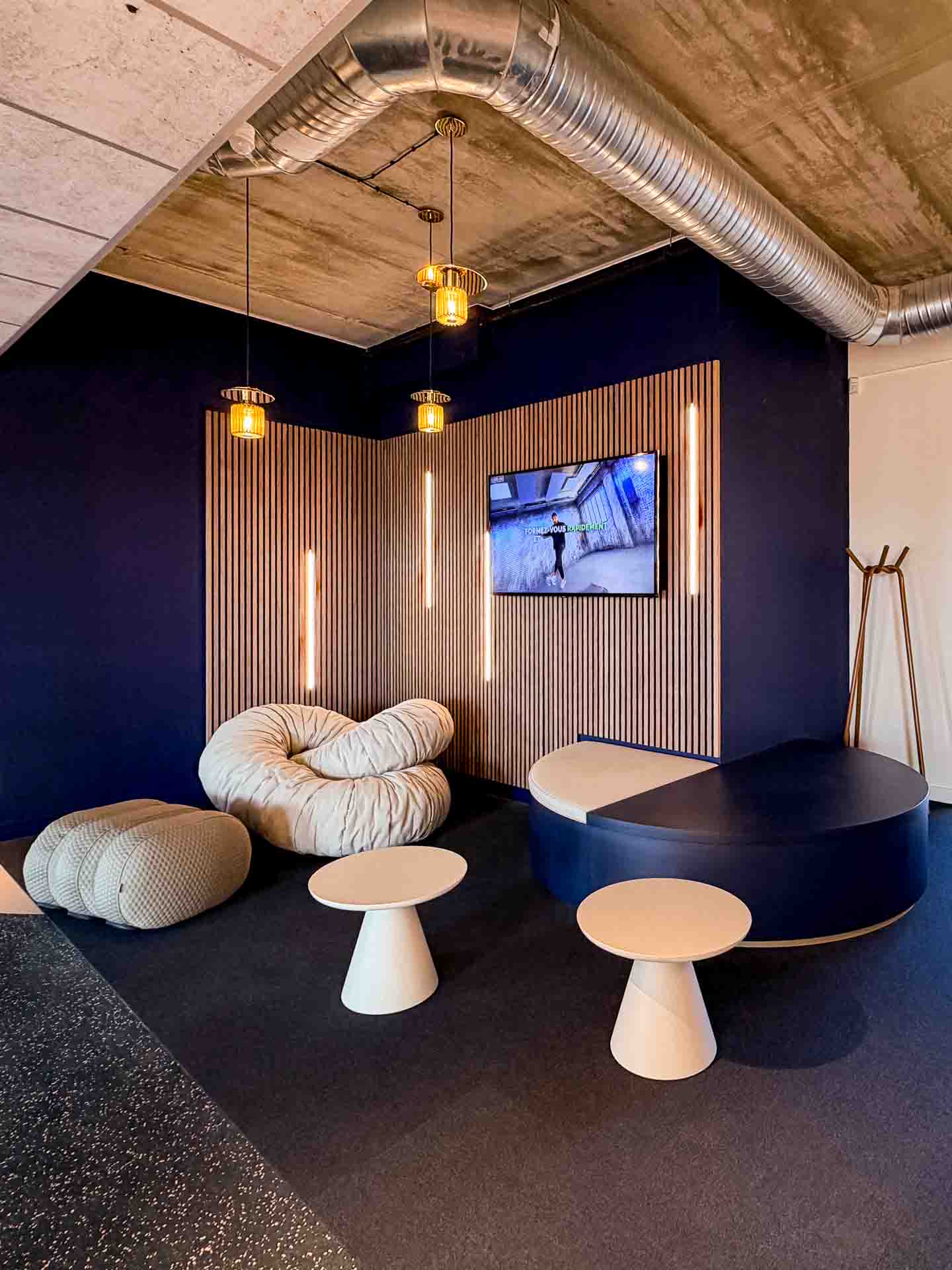 Hall Orange Bleue aménagé par Othéa, avec habillages en bois et lumière naturelle.